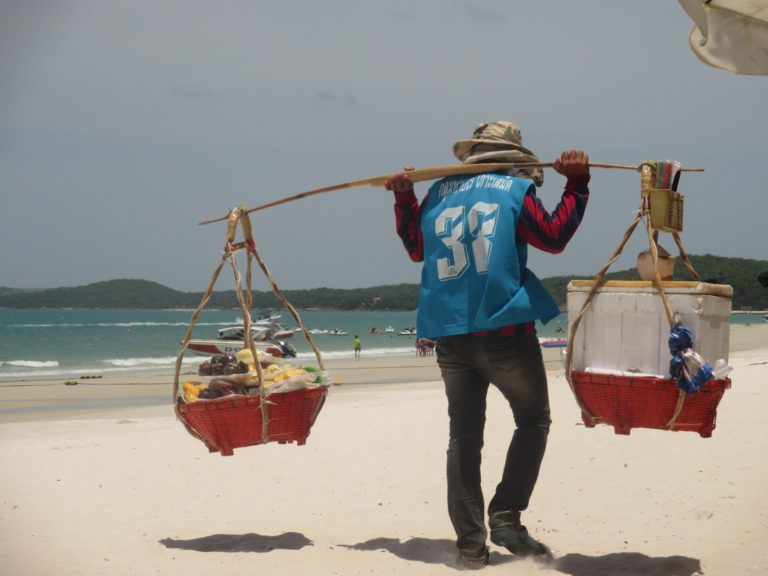 A man carries two heavy loads on his shoulders