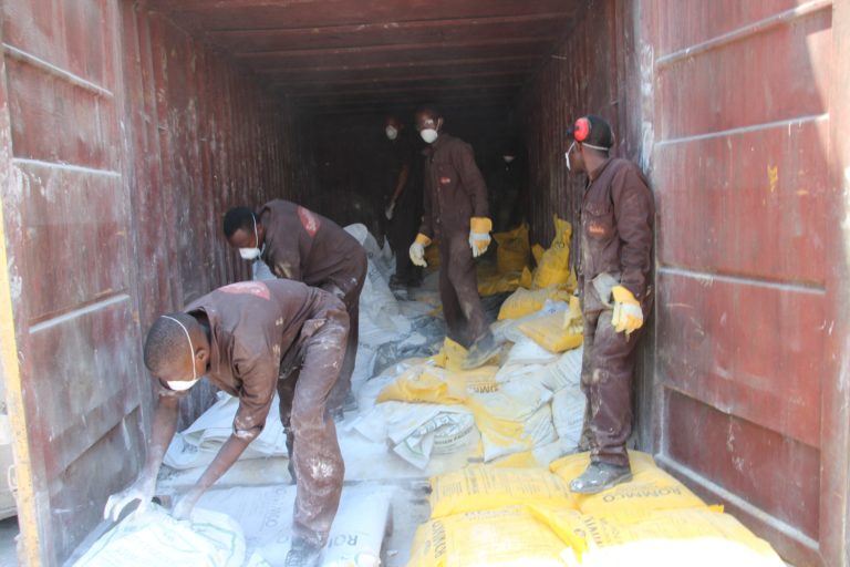 Workers handling bags of powder used for making paint