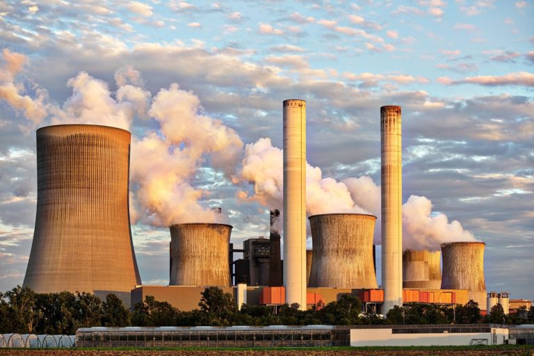 A nuclear power plant, with steam rising from the large cooling towers