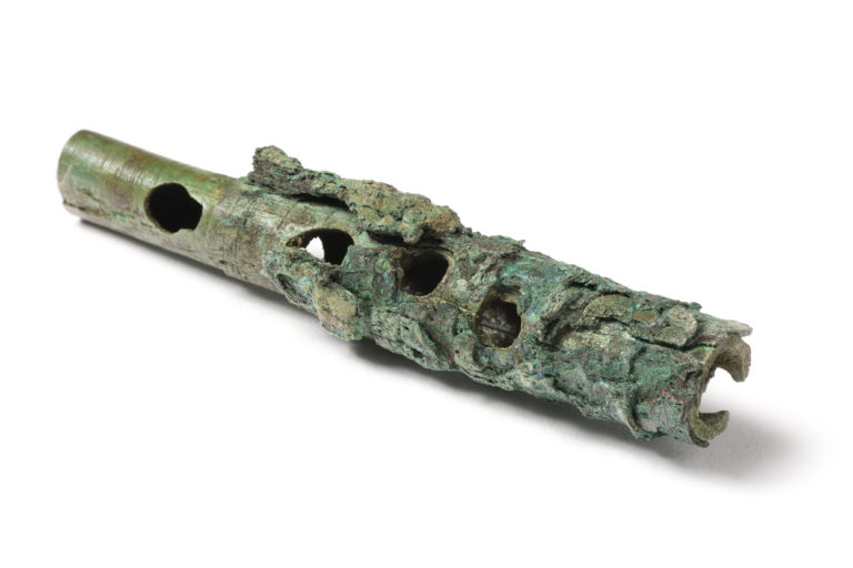 photo of a fragment of a wooden flute with the holes showing