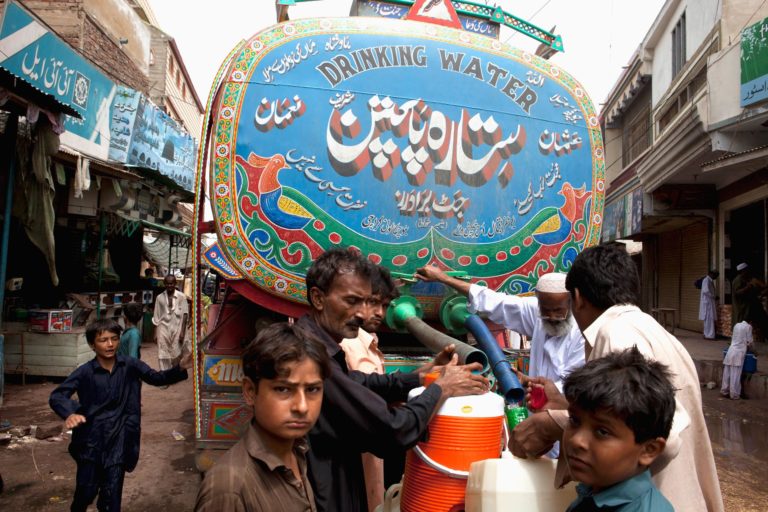 A water tanker distributes drinking water in the city of Sujawel, Pakistan, which had been devastated by flooding
