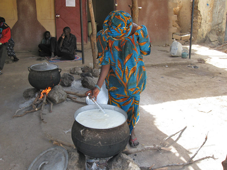 Picture of a woman heating milk.