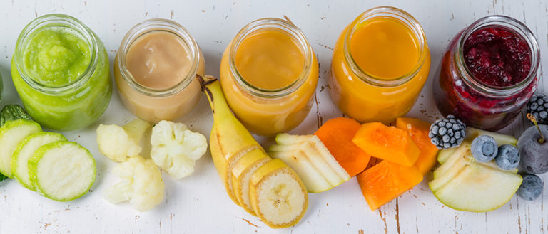 Colorful baby food purees in glass jars with ingredients. Healthy organic baby food concept. Starting solid food, delivery