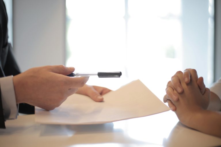 A close-up photograph of hands across the table.