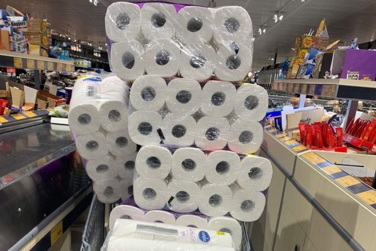 shopping cart filled well above its capacity with toilet paper