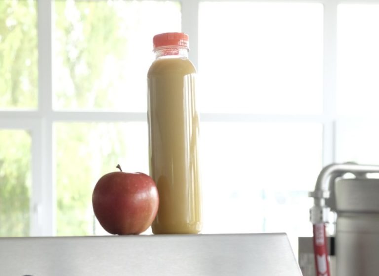 Photo of a whole apple and a bottle of apple juice