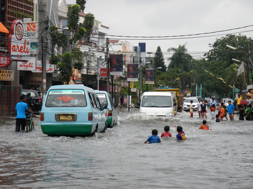 children swimming in flooded street