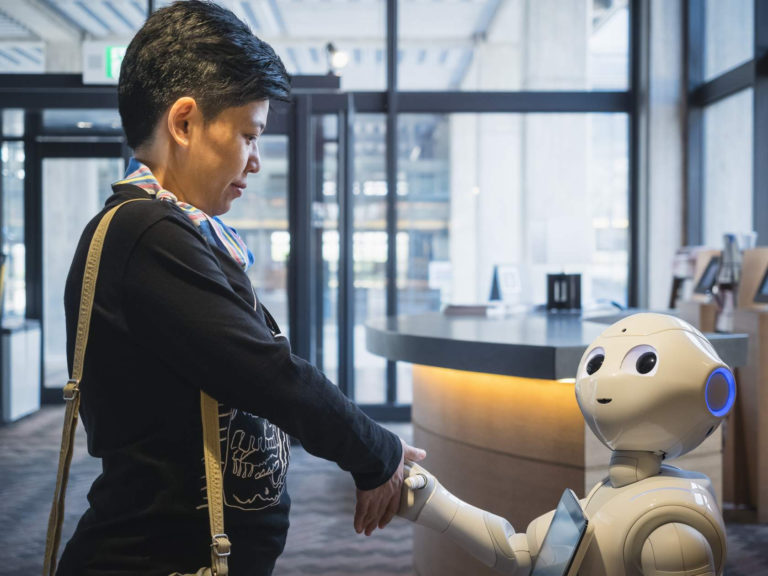 Softbank's Pepper Robot greets and assists a tourist