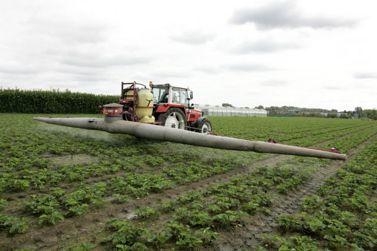 Spraying pesticides in a field, using a tractor with a closed cabin