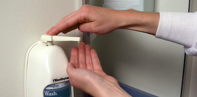 hand using sanitiser pump