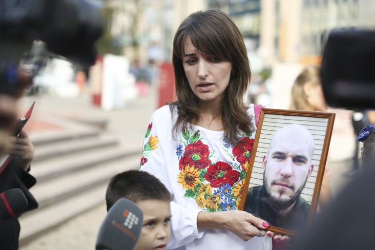 A woman shows a photograph of her loved one who is missing