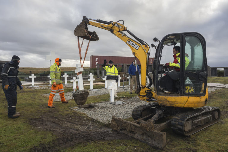 A mechanical digger clearing grave sites in a cemetery in order to identify the deceased to confirm identity