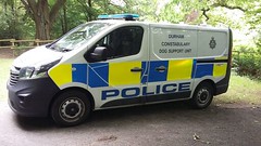 Police dog unit van parked next to a field