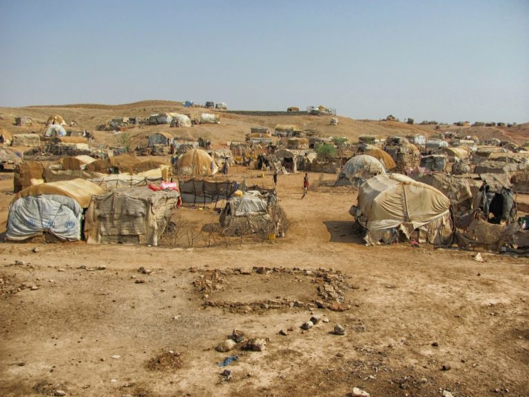 The image shows tents in a refugee camp.
