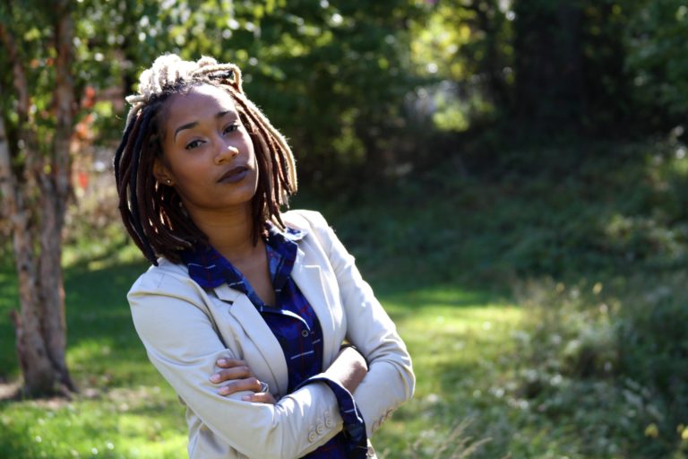 Woman with dreadlocks standing in a garden