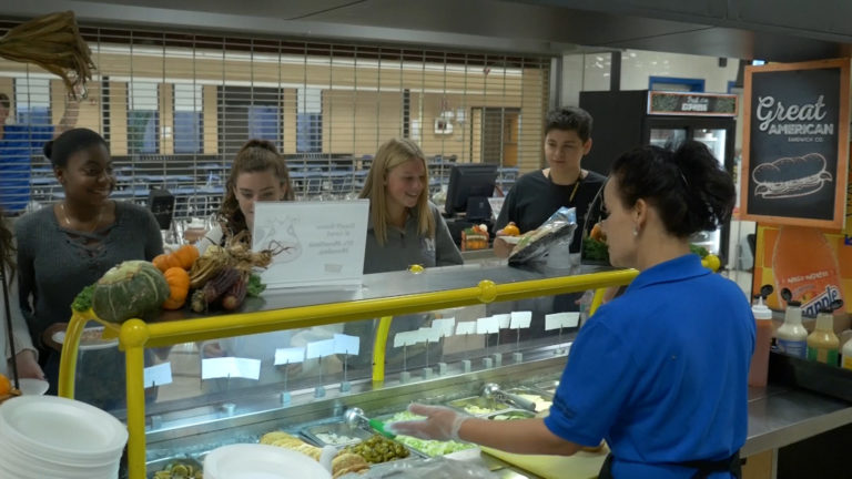 school lunch staff serves food to students
