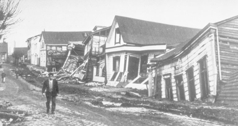 Showing damaged and collapsed houses on a street in Valdivia after the 1960 megaquake