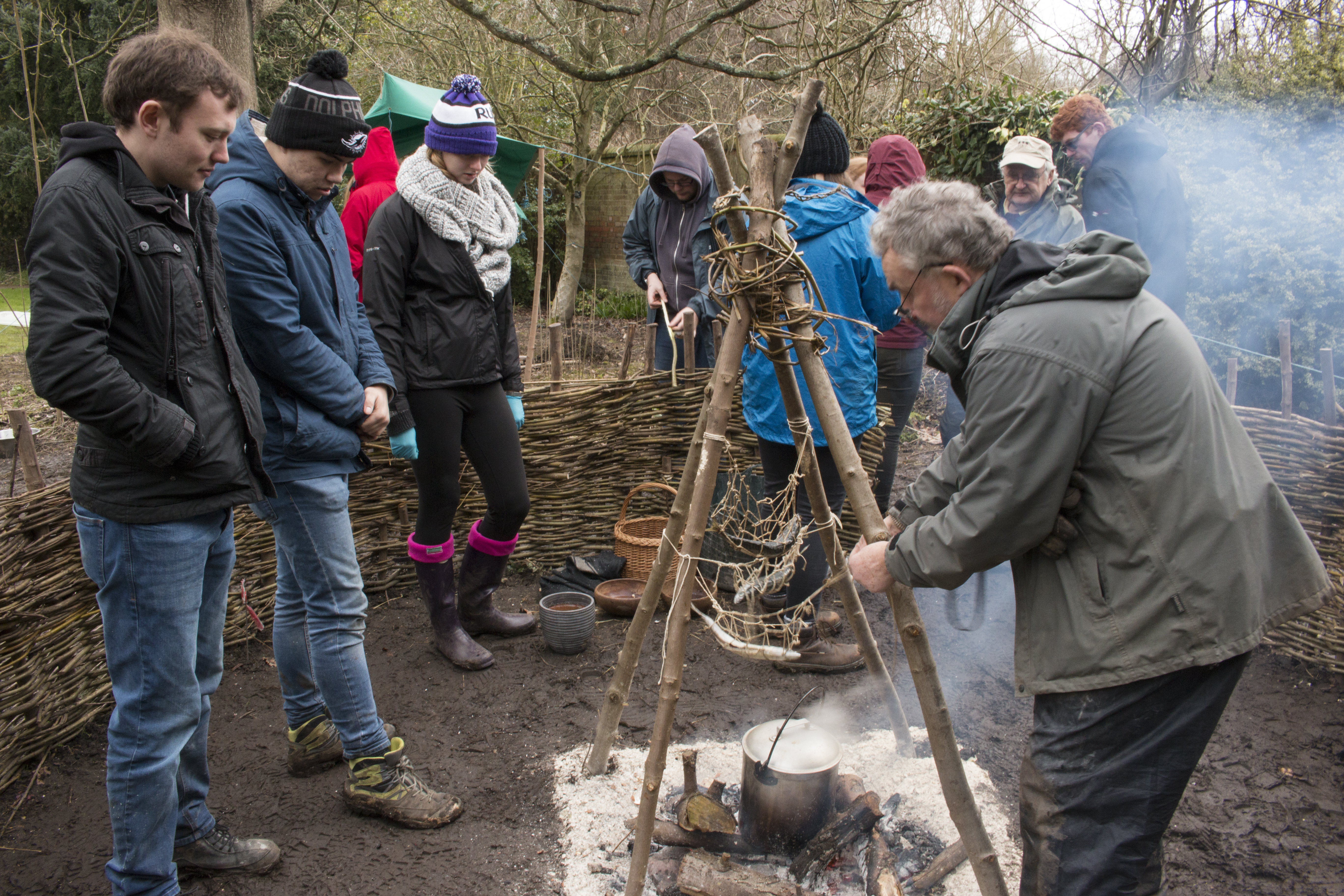 A photo of Martin Bell and a group of students conducting experiments on a hearth and chalk surface