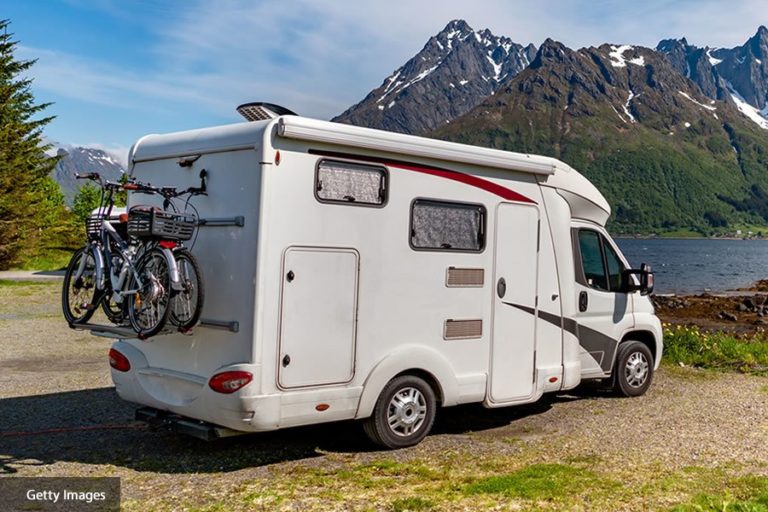 Photograph of campervan parked by a lake - Getty Images