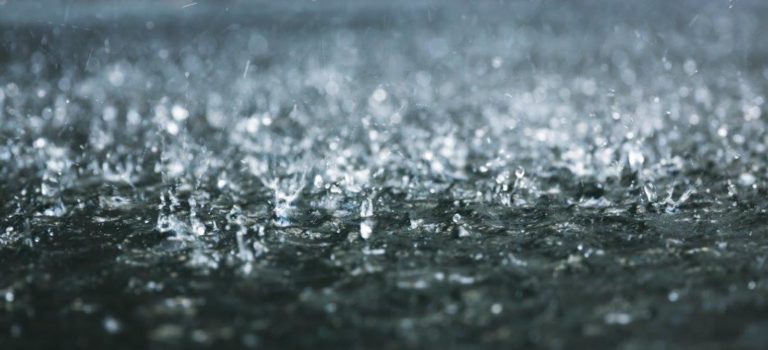 Photograph of rain falling into a puddle