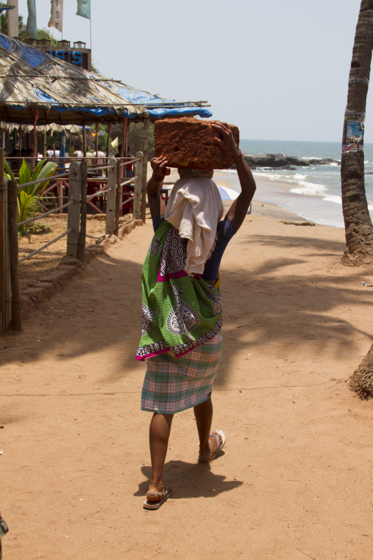 Woman carrying a stone for building on her head