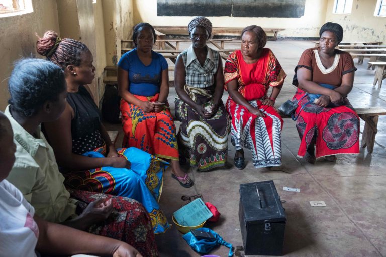 Group of Zambian women sitting in a circle for discussion about savings