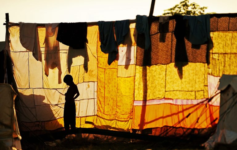 Photograph of a boy silhouetted in front of a washing line at Utmanzai relief camp near Charsadda, northwest Pakistan, on September 24, 2010