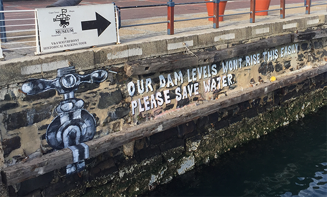 Picture showing public art at V&A docks with the message "Our dam levels won't rise this easily please save water" and a picture of a tap