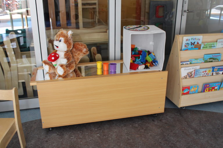 photograph of a bench of toys in an early childcare centre that has no chairs