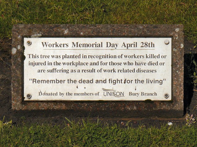 The plaque under "The Workers' Tree", Whitehead Gardens, near Manchester, UK, reads: This tree was planted in recognition of workers killed or injured in the workplace and for those who have died or are suffering as a result of work-related diseases. "Remember the dead and fight for the living" Donated by members of the UNISON Bury Branch