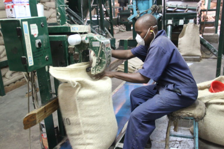 Worker sitting on a chair while handling a machine