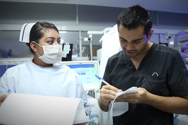 Nurse and doctor checking data on paper forms in the NICU