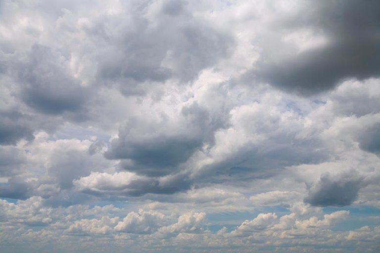 Photograph of a cloudy sky with just a few glimpses of blue visible in the cloud breaks