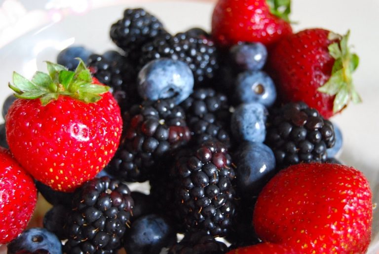 A photograph showing a range of berries including strawberries, raspberries and blueberries
