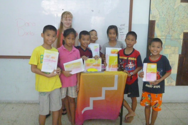 Children at Pattaya Orphange in Thailand pose with their renditions of the FutureLearn flag.