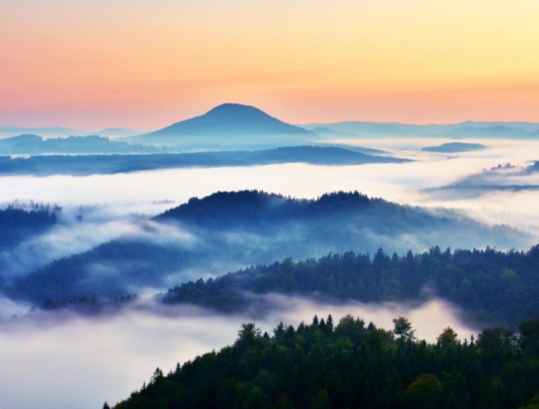 Photograph of fog sitting in valleys across a range of hills