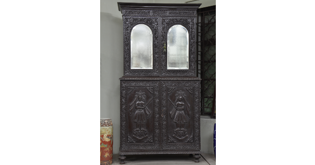 Wooden cupboard with carving of Zarathustra A black wooden cupboard. The upper half has mirrors and the lower half has the image of Zarathustra