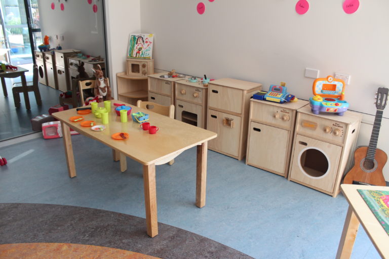 photograph of a table of play doh in an early childcare centre that has no chairs