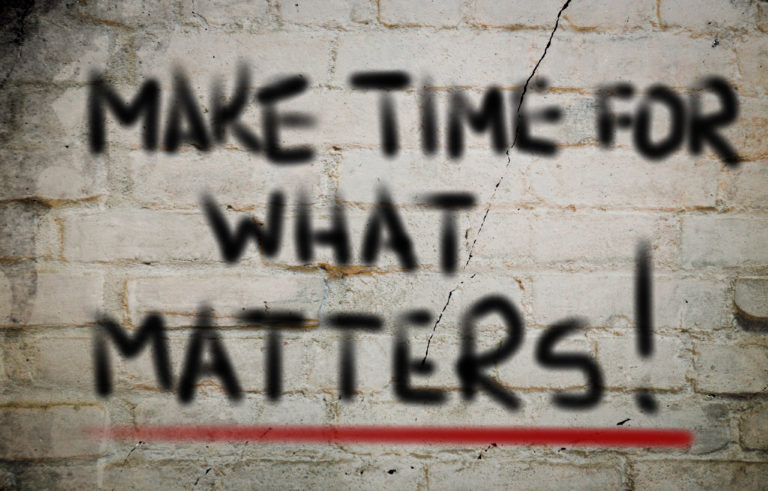 A wall with the words Make time for what matters! painted on 
