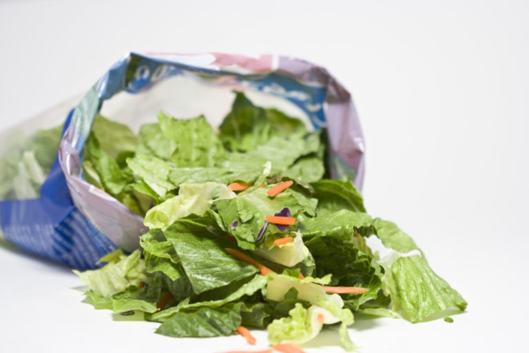 bag of salad, opened, with leaves spilling out