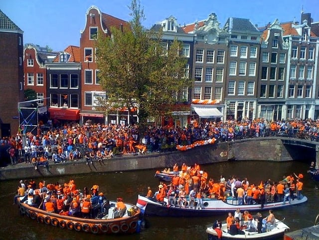 People celebrate King's Day on the canals of Amsterdam