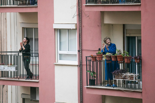 Women on their balconies during the 2020 lockdown in Italy, singing, clapping and smiling