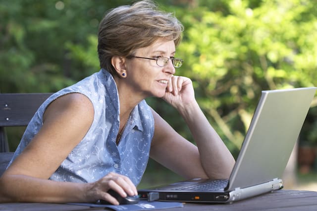 A lady working outdoors on the laptop