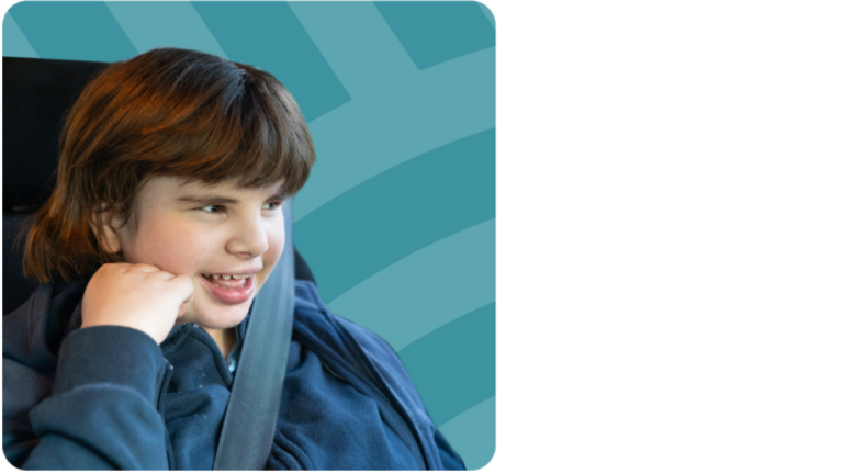 Young child smiles while looking out the window in car seat