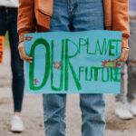 气候活动家在抗议活动中说“我们的星球，我们的未来”的标志说
