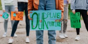 Climate activist holds sign saying 'Our planet, our future' at a protest