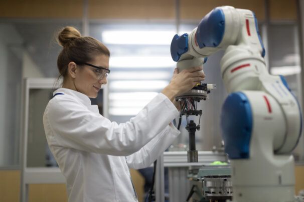 Mid adult female engineers working with robotic arm