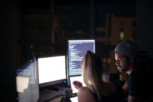 Rear shot of computer programmers working on new code.
