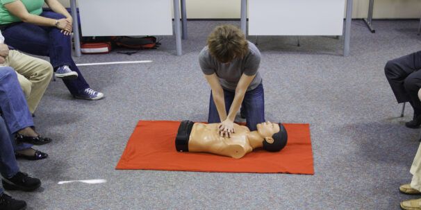 First aider performs CPR on doll