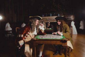 People dressed up in Royal dress sit at a table.